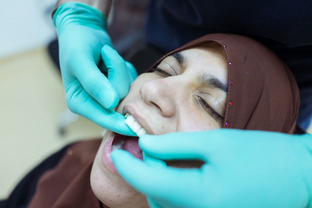 mujer musulmana que blanquea sus dientes