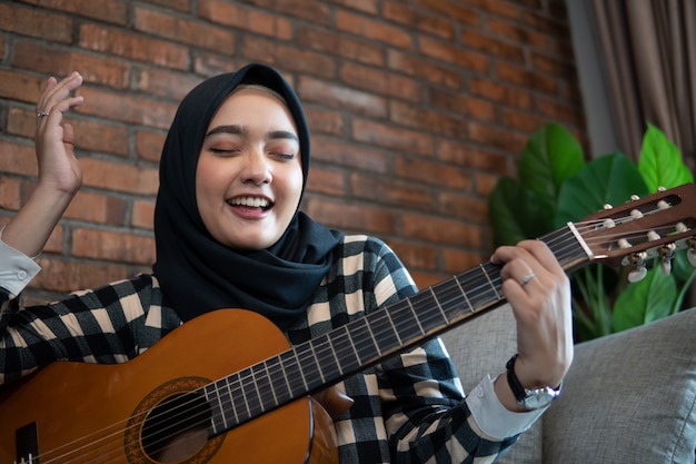 Mujer musulmana tocando la guitarra