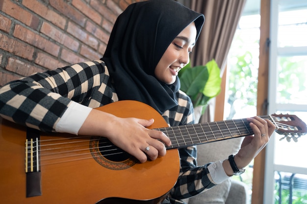 Mujer musulmana tocando la guitarra