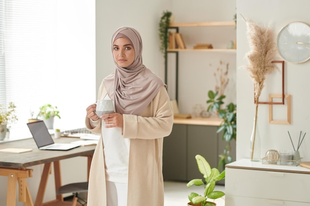 mujer musulmana tomando café