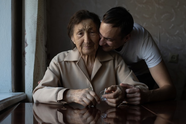 una mujer muy anciana y un nieto adulto