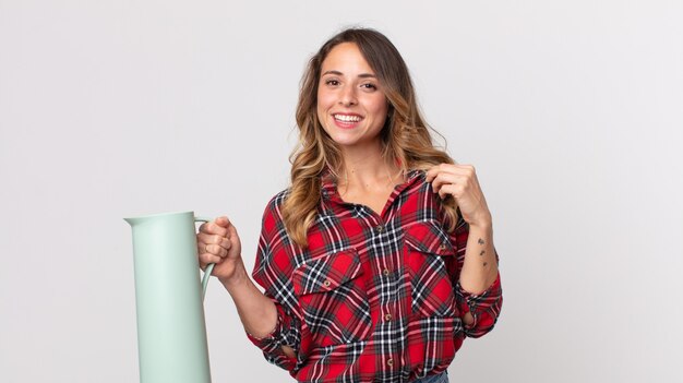 Foto mujer muy delgada que parece arrogante, exitosa, positiva y orgullosa y sosteniendo un termo de café