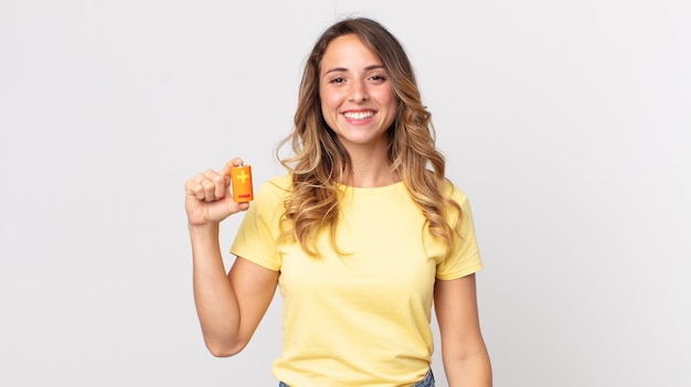 Mujer muy delgada que parece feliz y gratamente sorprendida y sosteniendo las baterías