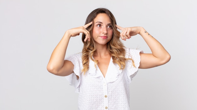 Foto mujer muy delgada que se siente confundida o dudando, concentrándose en una idea, pensando mucho, buscando copiar el espacio en el costado