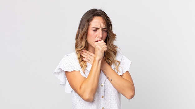 Mujer muy delgada que se siente enferma con dolor de garganta y síntomas de gripe, tos con la boca cubierta