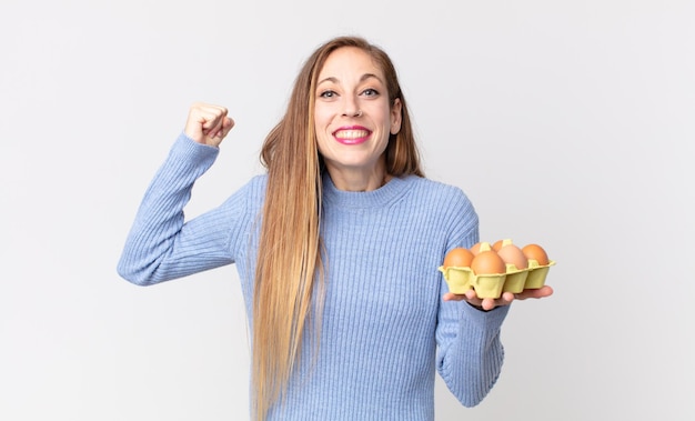 Mujer muy delgada sosteniendo una caja de huevos