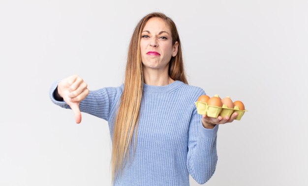 Mujer muy delgada sosteniendo una caja de huevos