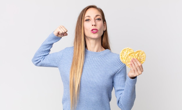 Mujer muy delgada sosteniendo una tortas de dieta de arroz