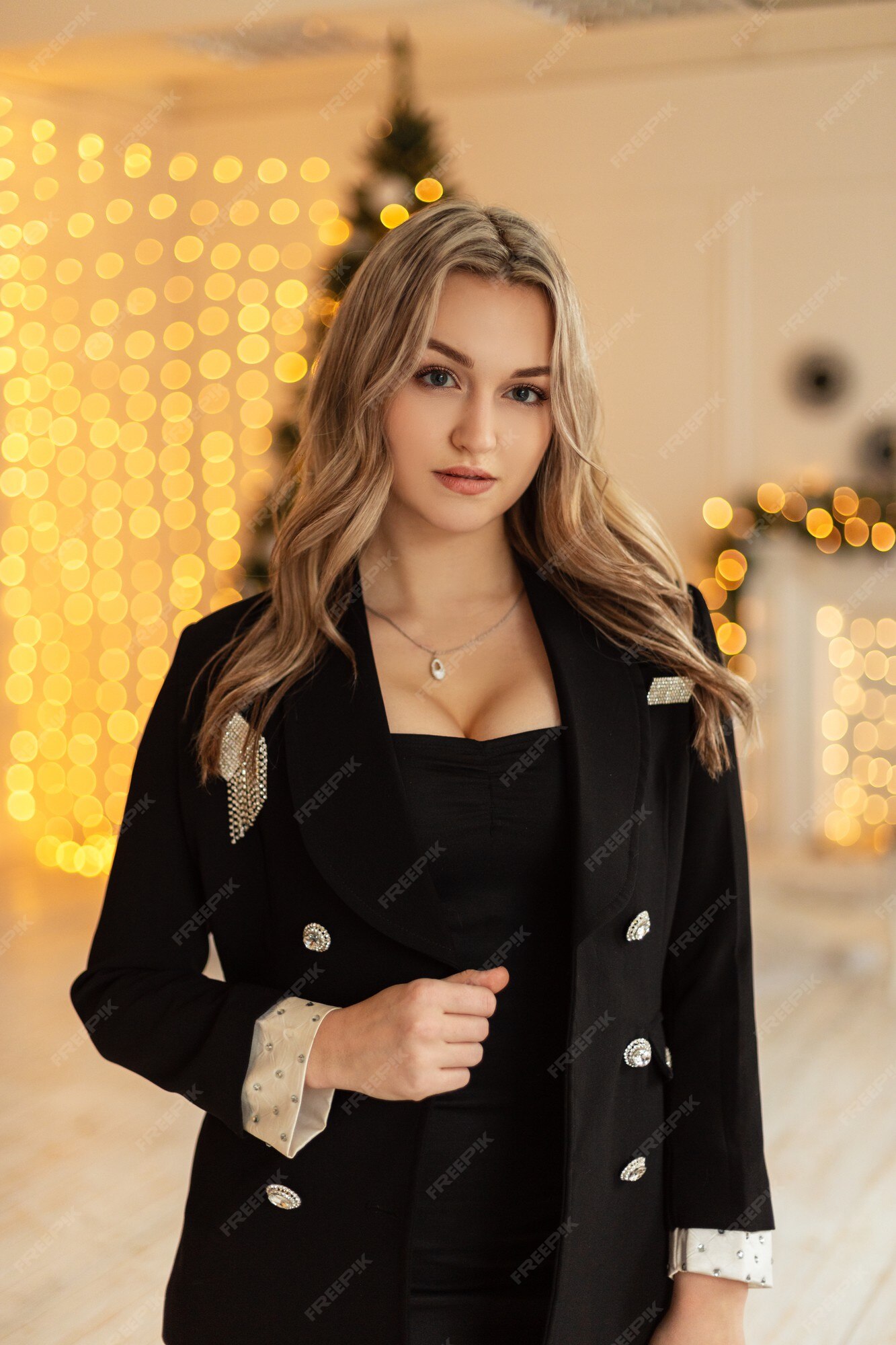 Mujer muy elegante con traje negro de moda blazer en el fondo de luces amarillas bokeh | Foto Premium