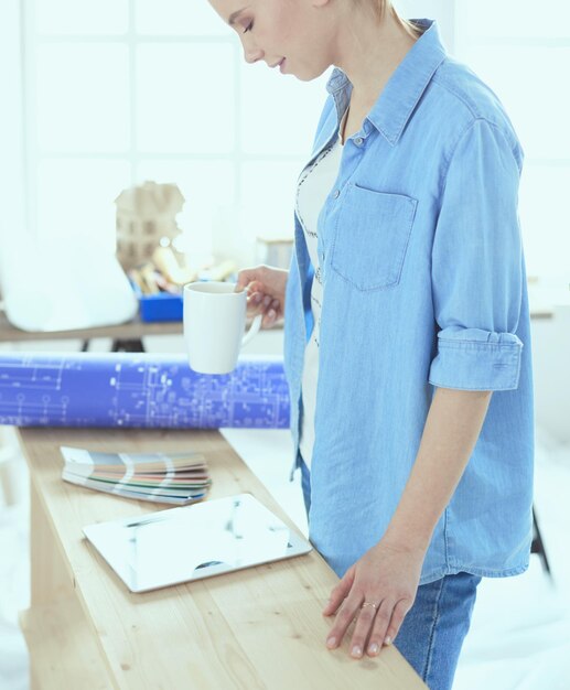 Mujer muy sonriente pintar la pared interior de la casa con rodillo de pintura