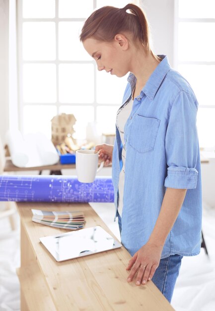 Mujer muy sonriente pintar la pared interior de la casa con rodillo de pintura