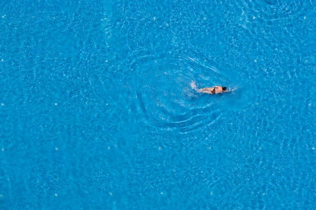 Mujer nadando en una piscina, vista superior, viajes de verano y concepto de vacaciones