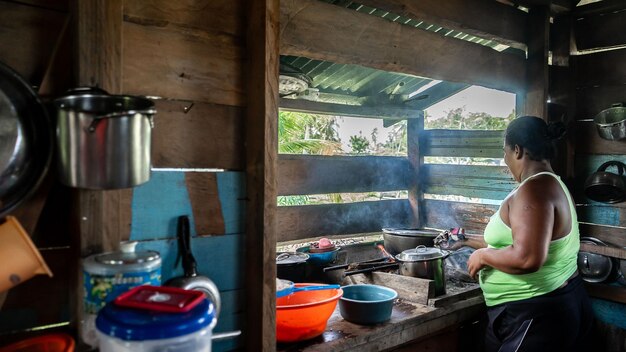 Foto mujer nativa y afrodescendiente cocinando dentro de su humilde casa de madera en el caribe de nicaragua039s