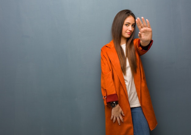 Mujer natural joven poniendo la mano delante