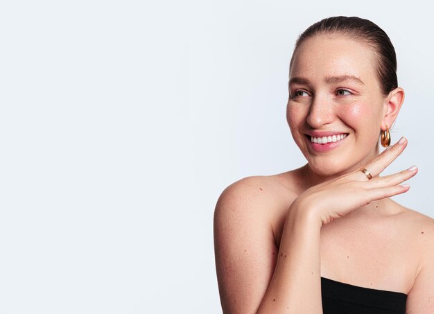 Mujer natural sonriente con la mano debajo de la barbilla