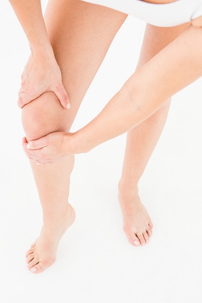 Mujer natural tocándose la rodilla dolorida