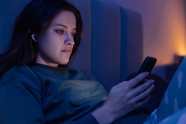 Mujer navegando en internet con un teléfono inteligente a altas horas de la noche debido al apagón