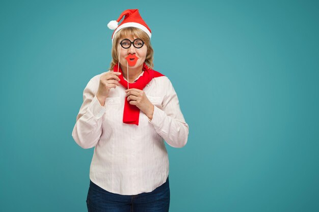 Mujer de Navidad con una camisa blanca y jeans sobre un fondo azul.