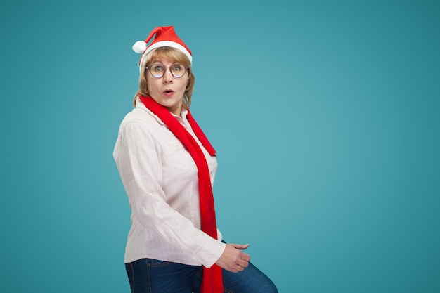 Mujer de Navidad en camisa y jeans sobre fondo azul.