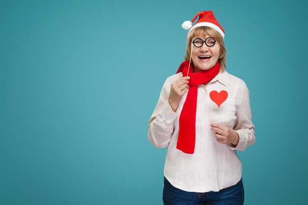 Mujer de Navidad en camisa y jeans sobre fondo azul.