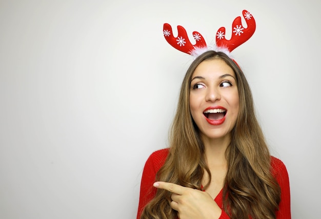 Mujer de Navidad gesticulando con el dedo y mirando hacia el lado