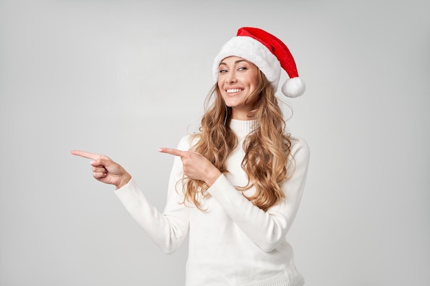 Mujer de Navidad Santa sombrero suéter fondo de estudio blanco