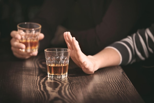 Mujer negándose a beber alcohol en el primer plano de la barra