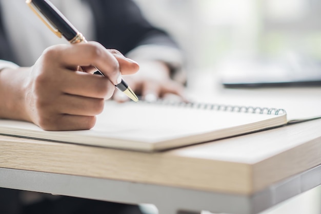 Mujer de negocios africana escribe en un cuaderno en la oficina