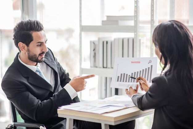 Una mujer de negocios africana habla con un hombre de negocios o un socio sobre las ganancias de la empresa o el crecimiento de las acciones