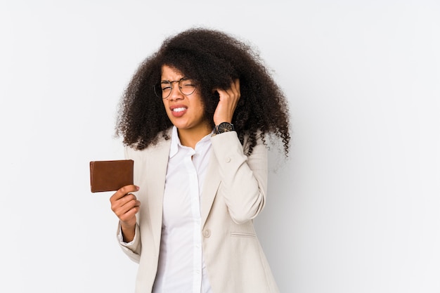 Mujer de negocios afro joven sosteniendo un crédito coche aislado Mujer de negocios afro joven sosteniendo un crédito carcovering orejas con las manos.