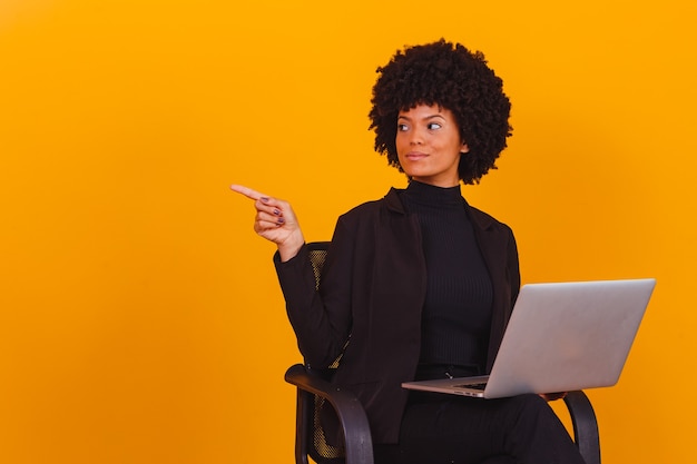 Mujer de negocios afro trabajando en línea con ordenador portátil.