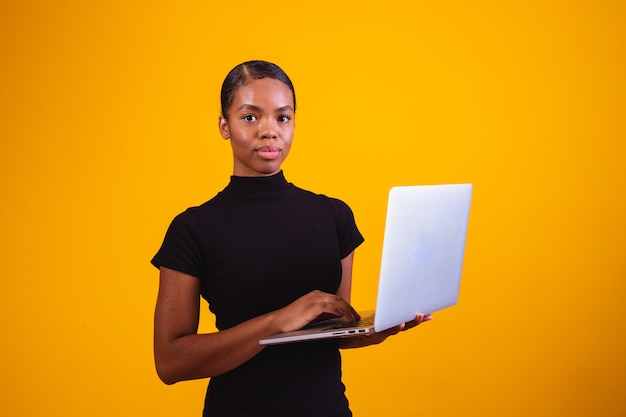 Mujer de negocios afro trabajando en línea con ordenador portátil.