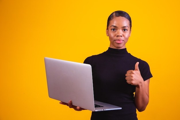 Mujer de negocios afro trabajando en línea con ordenador portátil.