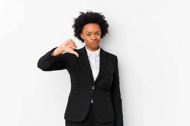 Mujer de negocios afroamericana de mediana edad sobre un fondo blanco aislado mostrando un gesto de aversión, pulgares hacia abajo. Concepto de desacuerdo.