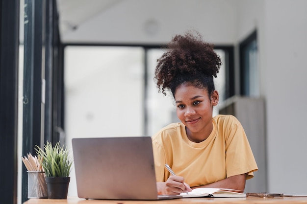 Mujer de negocios afroamericana o contadora con cabello afro usando una calculadora gráficos y gráficos para analizar datos de mercado balances de cuentas y ganancias netas