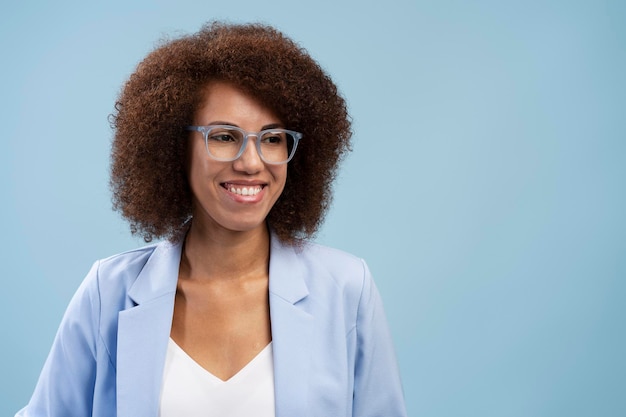 Una mujer de negocios afroamericana sonriente y confiada que usa anteojos elegantes aislada en el fondo