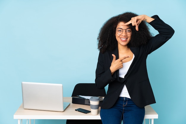 Mujer de negocios afroamericano que trabaja en su lugar de trabajo centrado en la cara. Símbolo de encuadre