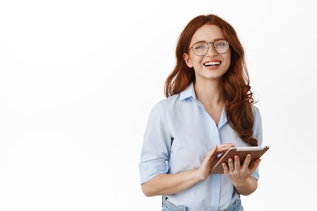 mujer de negocios, en, anteojos, y, tenencia, tableta, posar, blanco