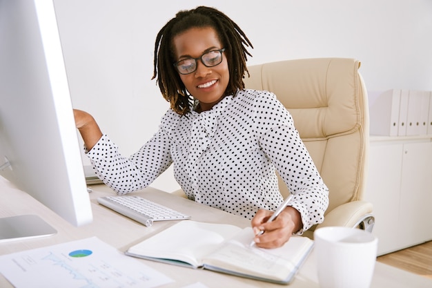 Mujer de negocios, en, anteojos, tomar notas, en, planificador