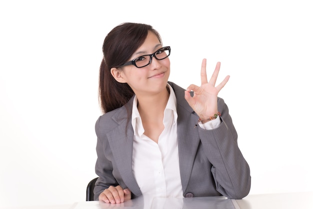 Mujer de negocios asiática le da un gesto OK, retrato de portarretrato sobre fondo blanco.