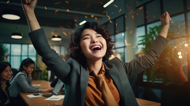 Mujer de negocios asiática emocionada en el lugar de trabajo celebrando el acuerdo exitoso