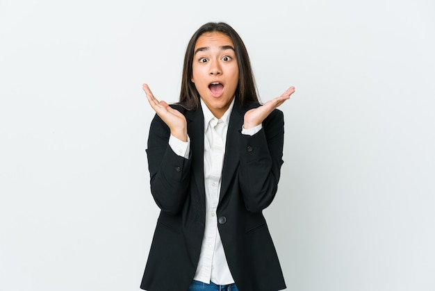 Mujer de negocios asiática joven aislada en la pared blanca sorprendida y conmocionada.