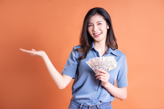 Mujer de negocios asiática joven posando sobre fondo naranja