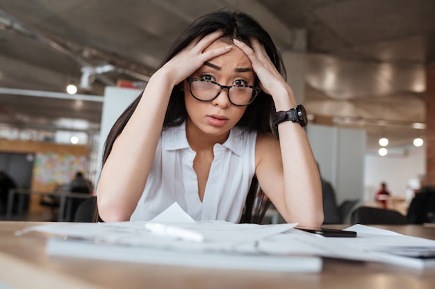 Mujer de negocios asiática molesta por la mesa