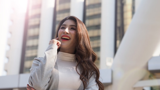 Mujer de negocios asiática de pie y dedo hacia arriba como una acción eureka y sentirse feliz que representan