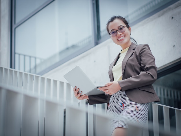 Mujer de negocios asiática con portátil feliz y sonrisa concepto éxito trabajo