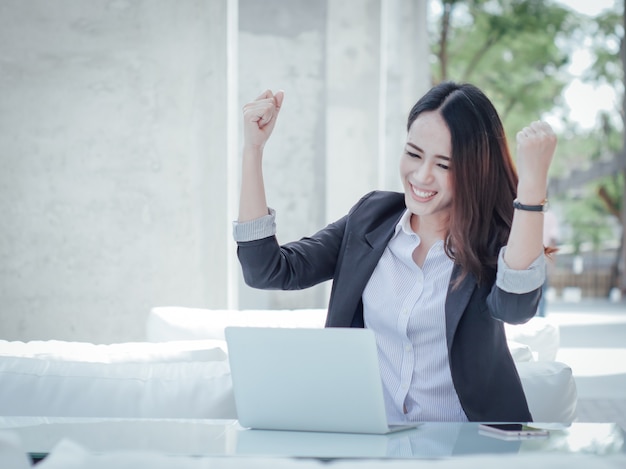 Mujer de negocios asiática con portátil feliz y sonrisa concepto éxito trabajo