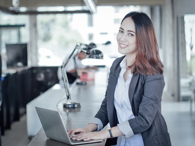 Mujer de negocios asiática con portátil feliz y sonrisa concepto éxito trabajo