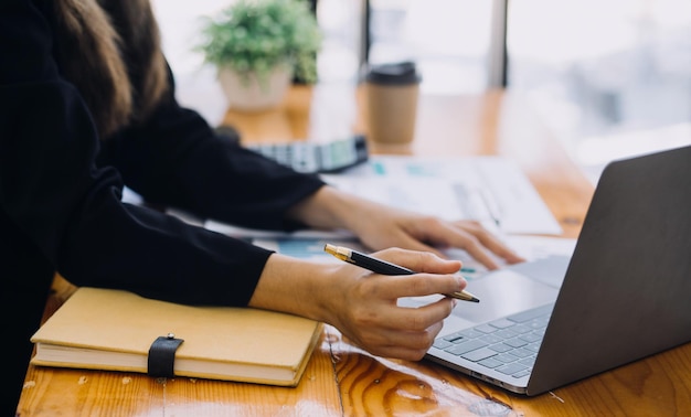 Mujer de negocios asiática que usa calculadora y computadora portátil para hacer finanzas matemáticas en un informe de impuestos de escritorio de oficina estadísticas contables y concepto de investigación analítica