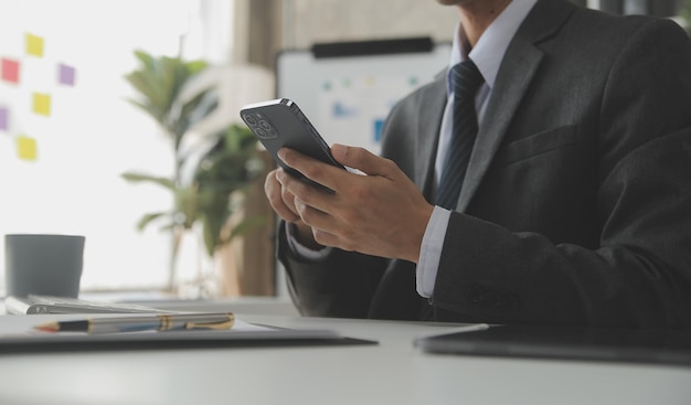 Mujer de negocios asiática que usa una computadora portátil y trabaja en la oficina con un documento de calculadora en el escritorio haciendo planificación analizando el concepto de análisis de finanzas de inversión del plan de negocios del informe financiero